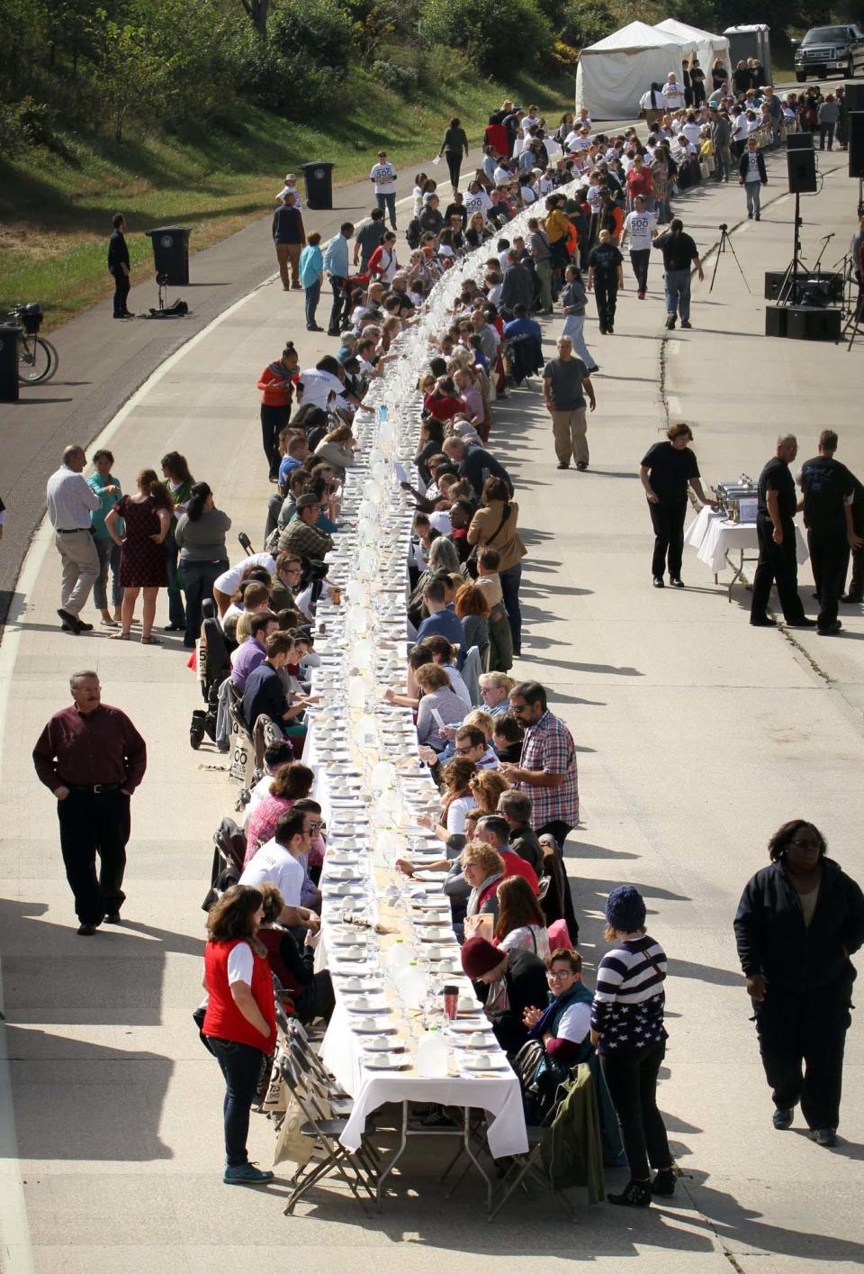 Diners gather around a 500-foot table on a stretch of the Akron Innerbelt during 500 Plates, a shared community meal, on Oct. 4, 2015.