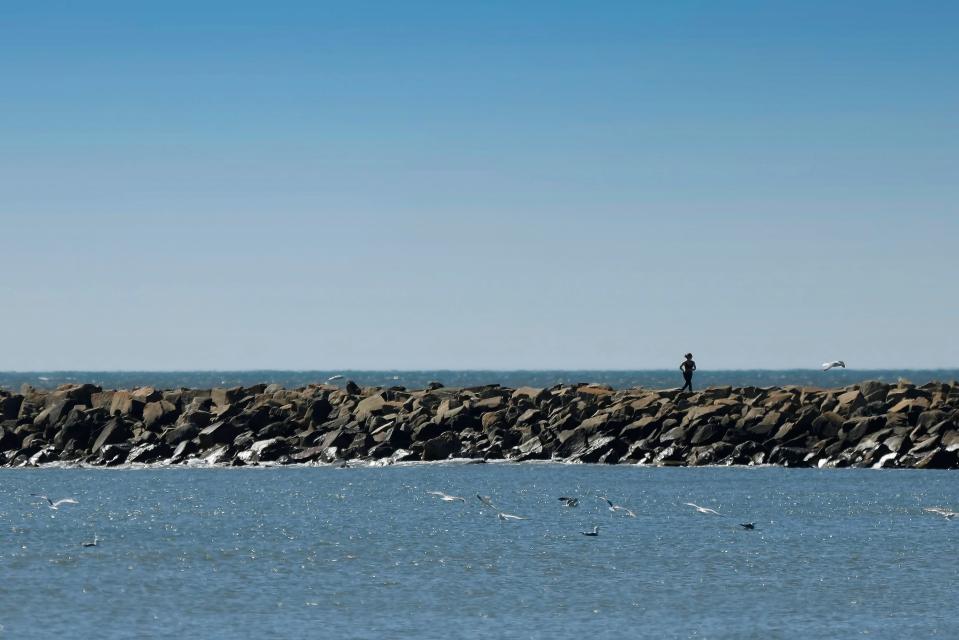 A woman runs across the Gooseberry Island causeway in Westport.