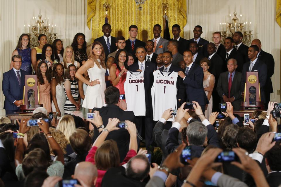 U.S. President Barack Obama poses with UConn women's basketball stars Stefanie Dolson (L) and Bria Hartley (2nd L) and men's team stars Ryan Boatright (2nd R) and Shabazz Napier (R) with jerseys of the NCAA basketball champion University of Connecticut Huskies men's and women's basketball teams in the East Room of the White House in Washington, June 9, 2014. REUTERS/Jim Bourg (UNITED STATES - Tags: POLITICS SPORT BASKETBALL)