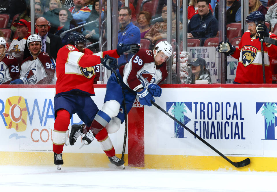 Florida Panthers right wing Givani Smith (54) checks Colorado Avalanche defenseman Kurtis MacDermid (56) into the boards during the first period of an NHL hockey game Saturday, Feb. 11, 2023, in Sunrise, Fla. (AP Photo/Reinhold Matay)