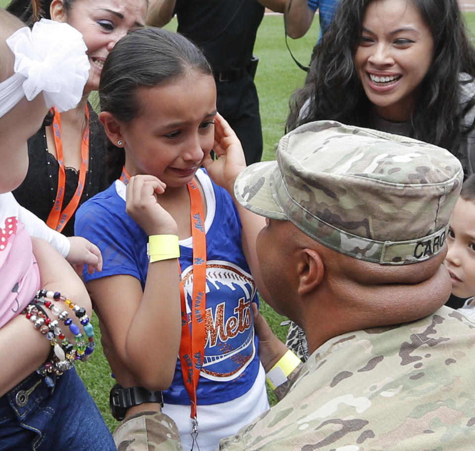 <p>U.S. Army Sgt. Wilson Caro, right, of Maspeth, N.Y., surprises his daughter Ciara, 6, on the field before a baseball game between the New York Mets and Miami Marlins at Citi Field in New York, Saturday, June 8, 2013. Sgt. Caro arrived home from Afghanistan and the Mets helped set up the surprise for Ciara. (AP Photo/Paul J. Bereswill) </p>