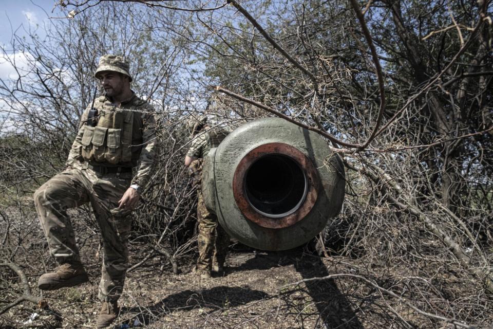 Soldiers check an artillery piece