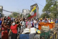 In this image made from video, anti-coup protesters shout at police in Yangon, Myanmar, Saturday, Feb. 27, 2021. Myanmar police on Saturday moved to clear anti-coup protesters from the streets of the country's biggest city Yangon. (AP Photo)