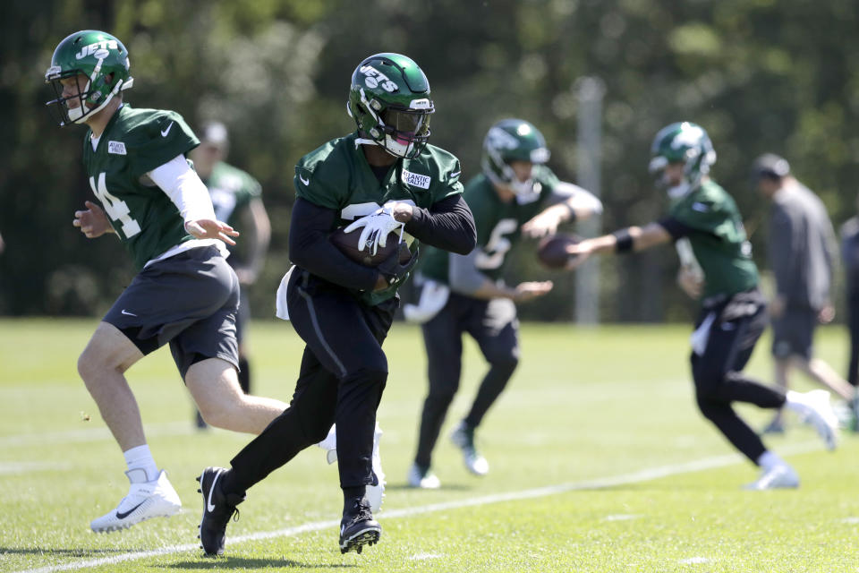 New York Jets quarterback Sam Darnold, left, hands off to running back Le'Veon Bell while running a drill at the team's NFL football training facility in Florham Park, N.J., Tuesday, June 4, 2019. (AP Photo/Julio Cortez)