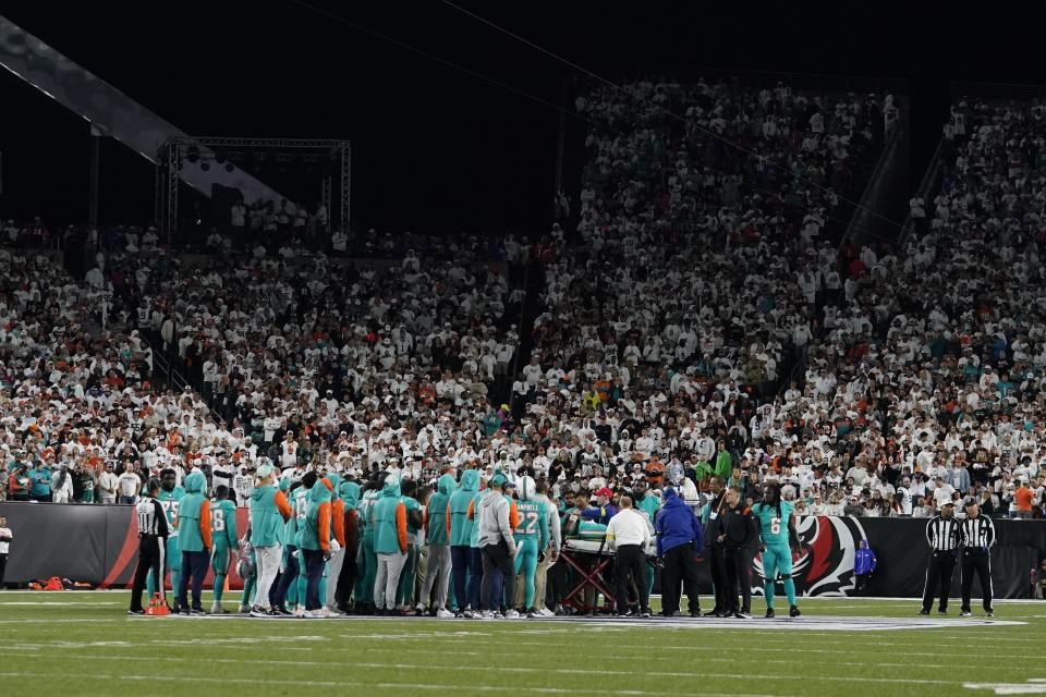 The entire Dolphins team surrounded Tua Tagovailoa when he was taken off the field on a stretcher during the first half of Thursday's game in Cincinnati.