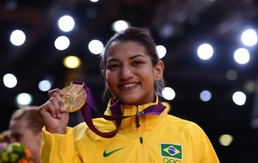 Brazil's Sarah Menezes poses on the podium with her gold medal at the London 2012 Olympics on July 28. Menezes revealed Sunday that her parents tried to stop her from taking up the sport which they believed was for men only. The 22-year-old from Brazil became the first woman from her country to win an Olympic judo gold