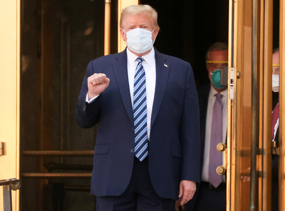 President Donald Trump makes a fist as he walks out the front doors of Walter Reed National Military Medical Center after a fourth day of treatment for the coronavirus disease (COVID-19) while returning to the White House in Washington from the hospital in Bethesda, Maryland, U.S., October 5, 2020. (Jonathan Ernst/Reuters)