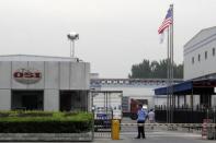 A security personnel stands guard in front of an OSI's food processing plants in Langfang, Hebei province, July 23, 2014. Shanghai police said on Wednesday they detained five people in an investigation into a Chinese-based supplier of foreign fast-food brands including KFC and McDonald's Corp over allegations the firm supplied out-of-date meat. REUTERS/Paul Carsten