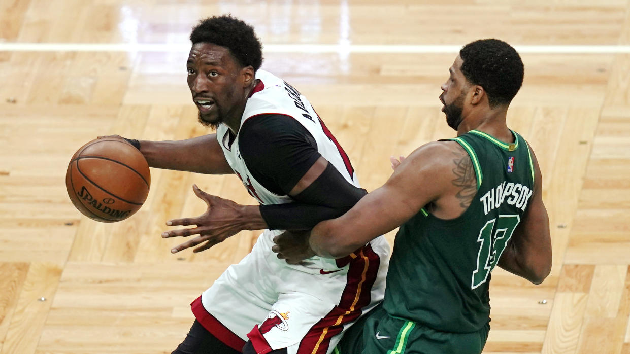 Miami Heat center Bam Adebayo, left, drives to the basket past Boston Celtics center Tristan Thompson