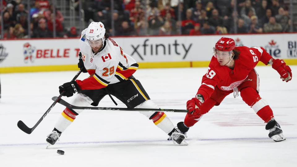 Calgary Flames center Dillon Dube (29) protects the puck from Detroit Red Wings left wing Tyler Bertuzzi (59) in the second period of an NHL hockey game Sunday, Feb. 23, 2020, in Detroit. (AP Photo/Paul Sancya)