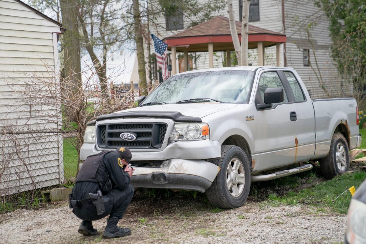Monroe County Sheriff's Deputy Cody Carena takes photos of a truck on Sunday that was allegedly struck by an suspected drunken driver before she smashed through a wall at the Swan Boat Club in Berlin Township during a child's birthday party Saturday.