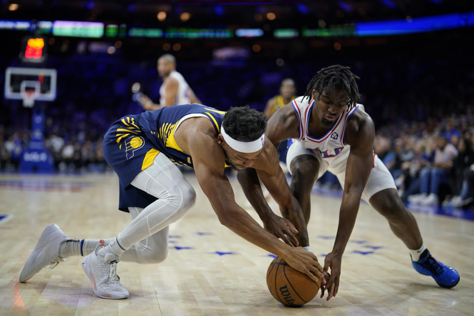 Philadelphia 76ers' Tyrese Maxey, right, and Indiana Pacers' Bruce Brown reach for a loose ball during the second half of an NBA basketball game, Sunday, Nov. 12, 2023, in Philadelphia. (AP Photo/Matt Slocum)