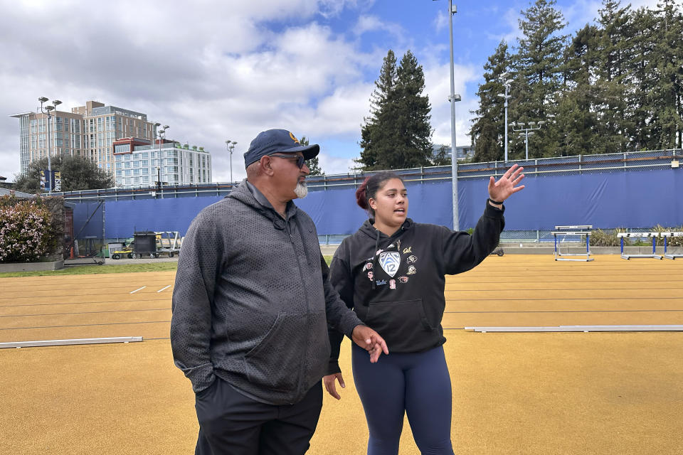 Carolina Visca, right, gestures while talking with California track and field coach Mohamad Saatara during practice in Berkeley, Calif., Friday, April 12, 2024. (AP Photo/Janie McCauley)