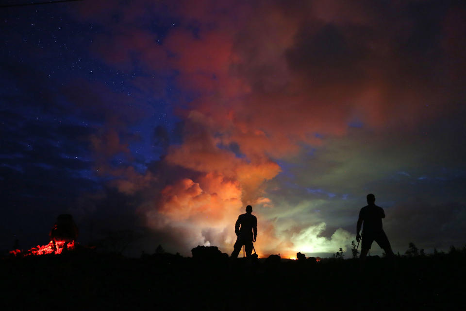 Photographers work as lava from active fissures illuminates volcanic gases from the Kilauea volcano.&nbsp;