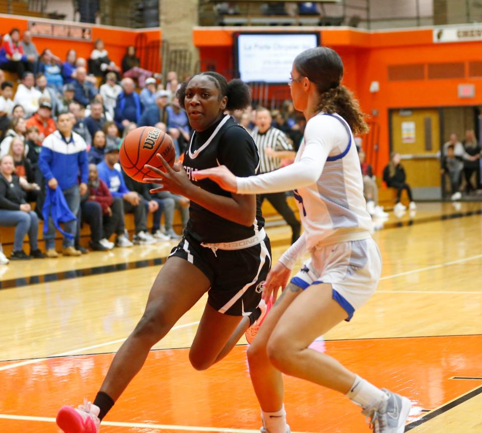 Washington junior Monique Mitchell drives to the hoop while being defended by Lake Central senior Nadia Clayton during a Class 4A girls basketball regional championship game Saturday, Feb. 10, 2024, at LaPorte High School.