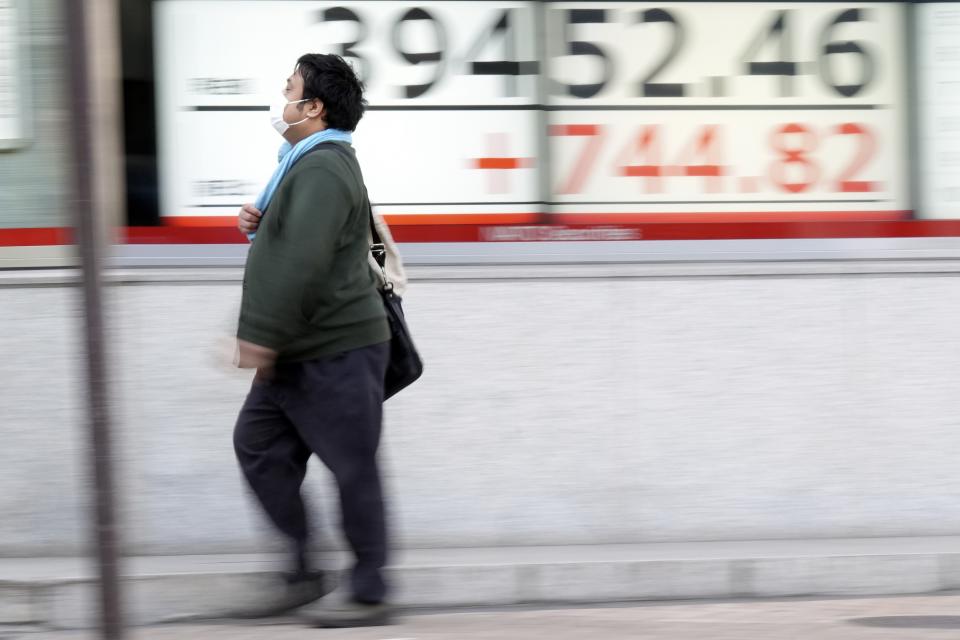 A person walks in front of an electronic stock board showing Japan's Nikkei 225 index at a securities firm Monday, March 18, 2024, in Tokyo. Asian stocks advanced Monday ahead of policy decisions this week by Japan’s central bank and the Federal Reserve. (AP Photo/Eugene Hoshiko)