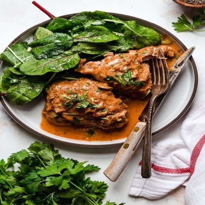 Chicken thighs in red wine vinegar sauce with spinach.