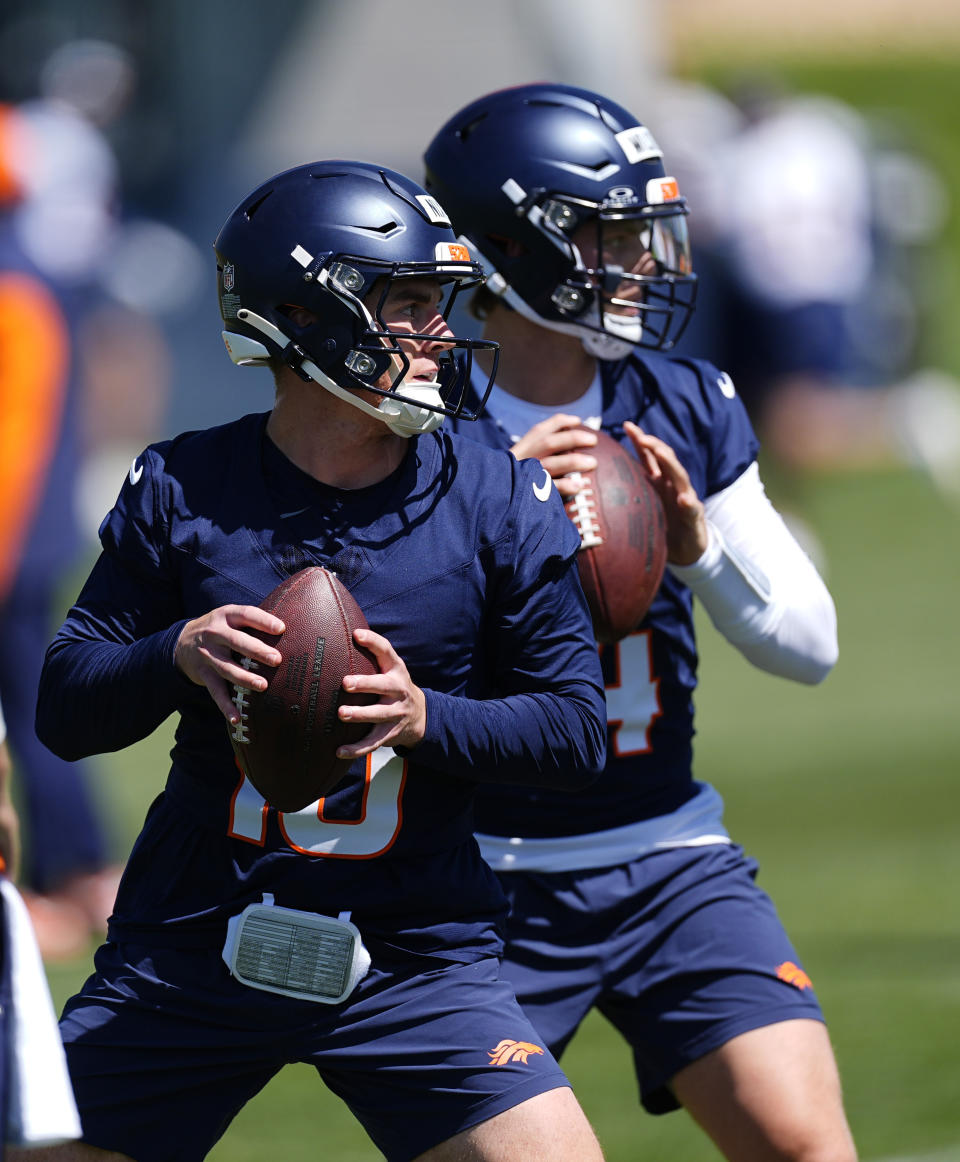 Denver Broncos quarterbacks Bo Nix, front, and Zach Wilson take part in drills during practice at the NFL football team's training headquarters Thursday, May 23, 2024, in Centennial, Colo. (AP Photo/David Zalubowski)