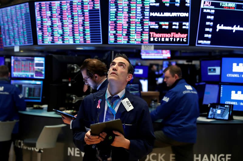 FILE PHOTO: Traders work on the floor of the New York Stock Exchange (NYSE) as the building prepares to close indefinitely due to the coronavirus disease (COVID-19) outbreak in New York