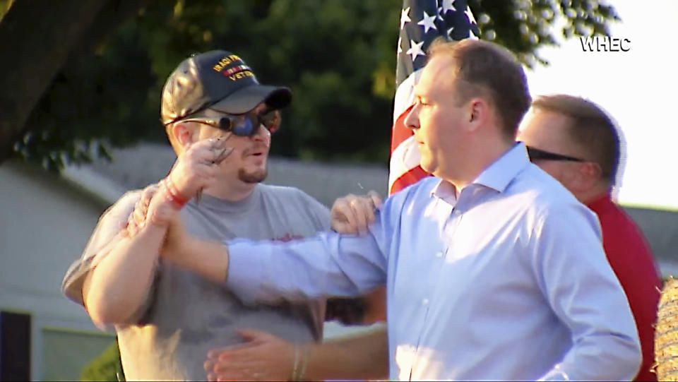 In this image taken from video provided by WHEC-TV, David Jakubonis, left, brandishes a sharp object as he attacks U.S. Rep. Lee Zeldin, right, as the Republican candidate for New York governor delivered a speech in Perinton, N.Y., Thursday, July 21, 2022. Jakubonis, 43, has been charged with attempted assault, arraigned and released, a Monroe County sheriff's spokesperson said. (WHEC-TV via AP)