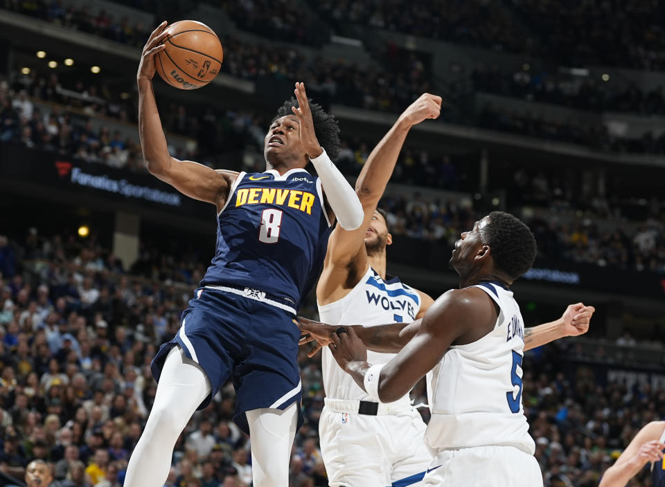 Denver Nuggets forward Peyton Watson, left, drives to the basket past Minnesota Timberwolves guard Anthony Edwards, right, and forward Kyle Anderson during the first half of an NBA basketball game Wednesday, April 10, 2024, in Denver. (AP Photo/David Zalubowski)