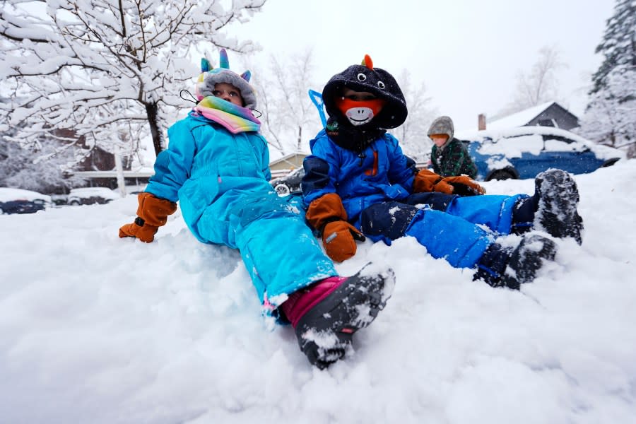 Four-year-old isabel Prileszky, left, and her 3-year-old brother, Adam, help build a fort of snow as a late winter storm dropped up to a foot of snow Thursday, March 14, 2024, in Denver. Forecasters predict that the storm will persist until early Friday, snarling traffic along Colorado’s Front Range communities. (AP Photo/David Zalubowski)