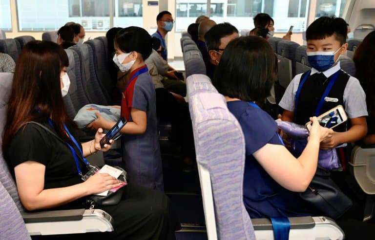 Des enfants et leurs parents jouent les rôles de personnel de cabine et de passagers au siège de China Airlines, à Taoyuan (Taïwan) le 8 août 2020 - Sam Yeh © 2019 AFP