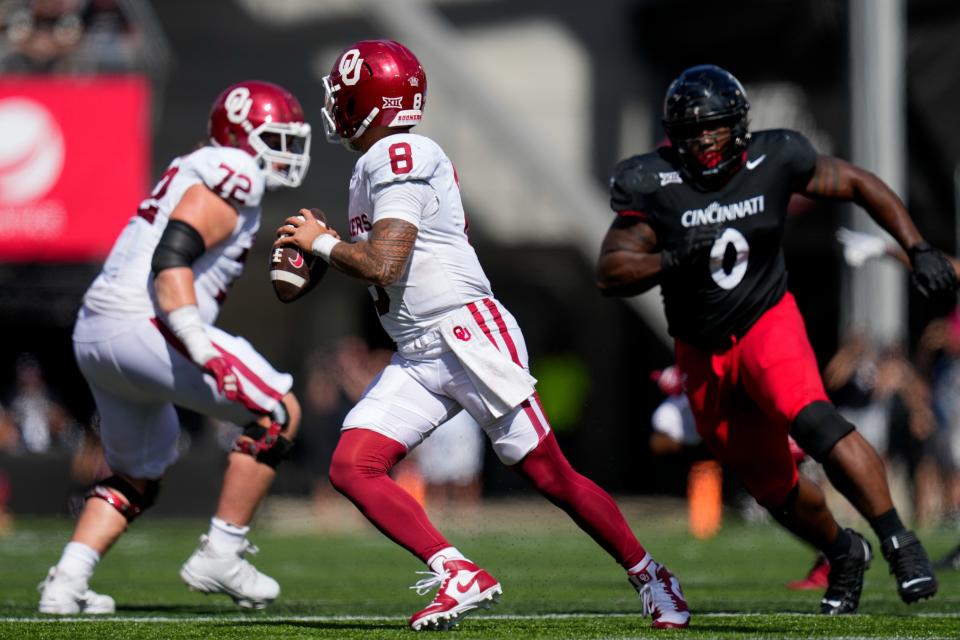 Oklahoma Sooners quarterback Dillon Gabriel (8) scrambles away from Cincinnati Bearcats defensive end Jowon Briggs (0) in the fourth quarter of the NCAA Big 12 football game between the Cincinnati Bearcats and the Oklahoma Sooners at Nippert Stadium in Cincinnati on Saturday, Sept. 23, 2023. The Bearcats lost their first Big 12 football game, 20-6, to the Sooners before a sellout crowd.