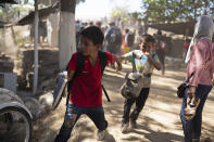 Migrant children run away from clashes with Mexican National Guards after their group crossed the Suchiate River on foot from Guatemala to Mexico, on the riverbank near Ciudad Hidalgo, Mexico, Monday, Jan. 20, 2020. More than a thousand Central American migrants hoping to reach United States marooned in Guatemala are walking en masse across a river leading to Mexico in an attempt to convince authorities there to allow them passage through the country. (AP Photo/Santiago Billy)