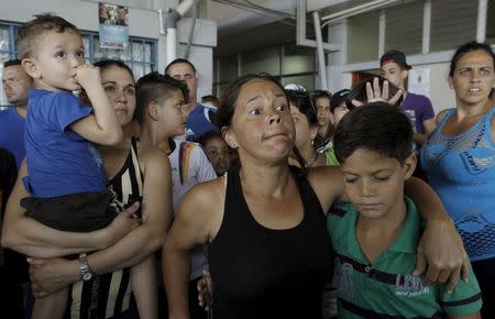 Cubans migrants listen as an immigration official speaks at the border post with Panama in Paso Canoas, Costa Rica November 14, 2015. REUTERS/Juan Carlos Ulate