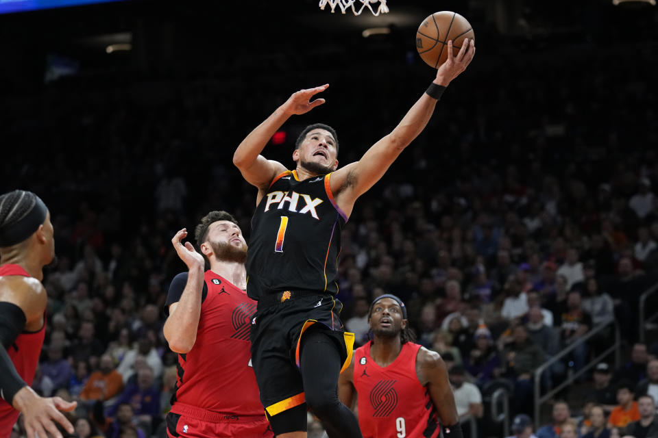 Phoenix Suns guard Devin Booker (1) shoots over Portland Trail Blazers center Jusuf Nurkic during the second half of an NBA basketball game, Friday, Nov. 4, 2022, in Phoenix. (AP Photo/Matt York)