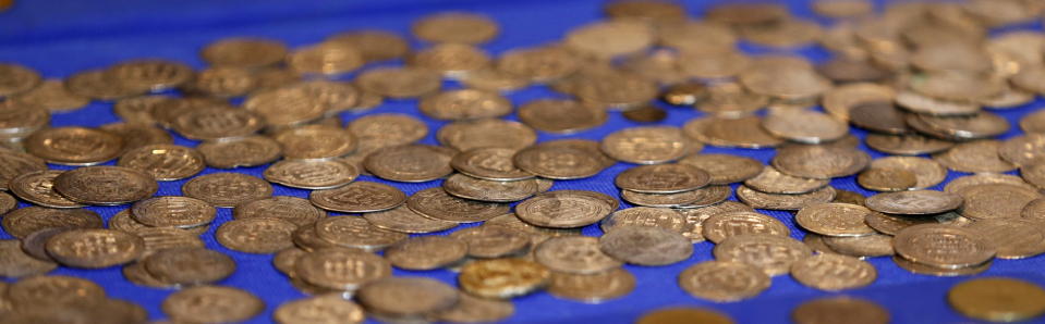 Recovered coins are seen at the National Museum of Iraq in Baghdad July 15, 2015. The U.S. handed back to Iraq on Wednesday antiquities it said it had seized in a raid on Islamic State fighters in Syria, saying the haul was proof the militants were funding their war by smuggling ancient treasures. The Iraqi relics were captured by U.S. special forces in an operation in May against an Islamic State commander known as Abu Sayyaf. They included ancient cylindrical stamps, pottery, metallic bracelets and other jewellery, and glass shards from what appeared to be a coloured vase. REUTERS/Thaier Al-Sudani 