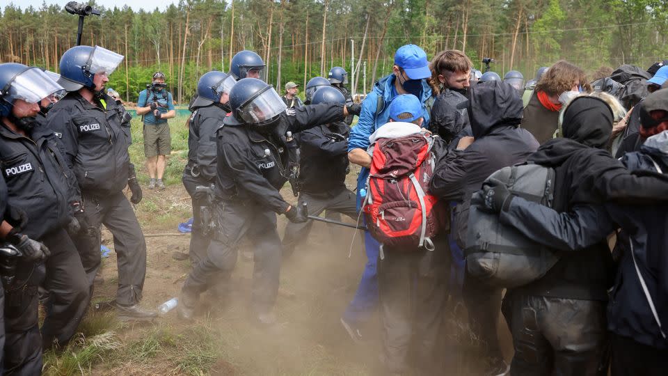 A police officer tries to push back protesters running toward the Tesla factory near Berlin on May 10, 2024. - Christian Mang/Reuters