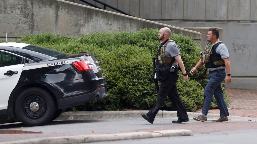 Two police officers move around a building on the University of North Carolina at Chapel Hill campus in Chapel Hill, N.C., on Monday, Aug. 28, 2023, after a report of an “armed and dangerous person” on campus. (Kaitlin McKeown/The News & Observer via AP)