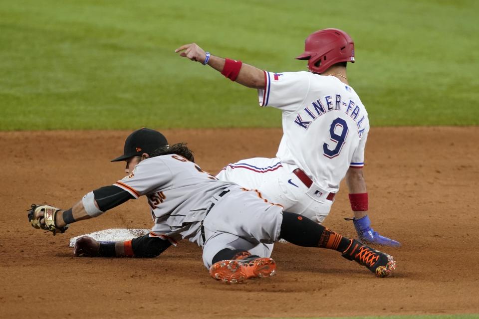 San Francisco Giants shortstop Brandon Crawford, left, is unable to tag Texas Rangers' Isiah Kiner-Falefa (9) who steals second in the ninth inning of a baseball game in Arlington, Texas, Wednesday, June 9, 2021. (AP Photo/Tony Gutierrez)