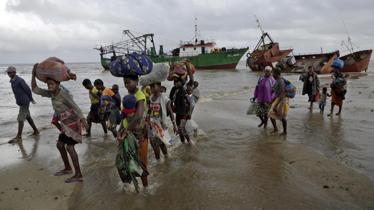 Familien kommen, nachdem sie 200 Kilometer vor Beira, aus einem überschwemmten Gebiet mit dem Boot gerettet wurden, am Strand an. Foto: Themba Hadebe/AP