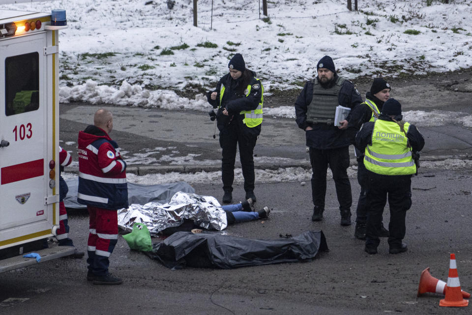 Police officers inspect corpses of people killed after a Russian rocket attack in Kyiv, Ukraine, Wednesday, Nov. 23, 2022. (AP Photo/Evgeniy Maloletka)