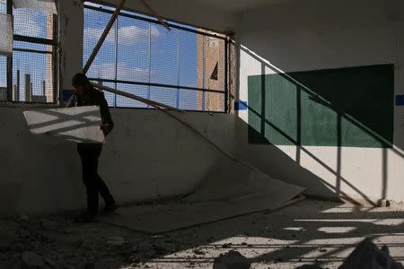 A man inspects the damage at a school after an airstrike in the rebel-held southern town of Bosra al-Sham, Deraa Governorate, Syria February 17, 2017. REUTERS/Alaa Al-Faqir