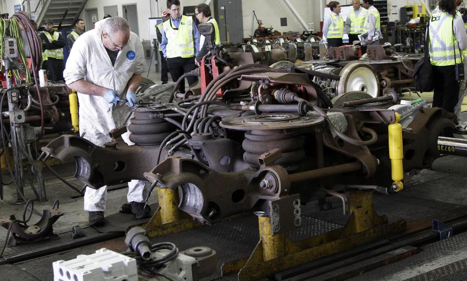 In this photo taken Wednesday, April 11, 2012, Bay Area Rapid Transit (BART) mechanic Doug Isonio works on parts for a BART train during a tour of the BART Maintenance Yard in Hayward, Calif. Driven by high gas prices and an uncertain economy, Americans are turning to trains and buses to get around in greater numbers than ever before. The aging trains and buses they’re riding, however, face an $80 billion maintenance backlog that jeopardizes service just when it’s most in demand. (AP Photo/Jeff Chiu)