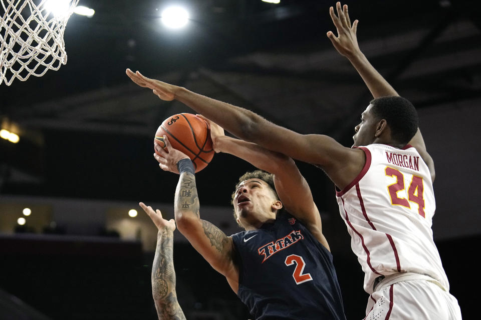 Cal State Fullerton guard Max Jones, left, shoots as Southern California forward Joshua Morgan defends during the first half of an NCAA college basketball game Wednesday, Dec. 7, 2022, in Los Angeles. (AP Photo/Mark J. Terrill)