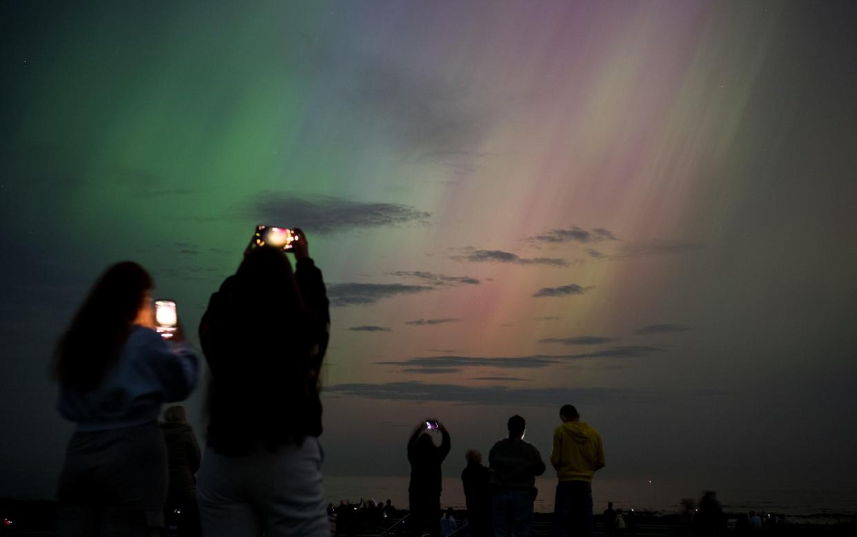 People watch the aurora from Whitley Bay in Tyne and Wear on Friday night