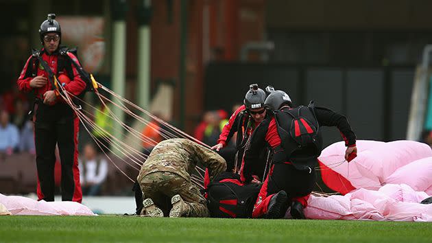 The parachutists check on their injured colleague. Image: Getty