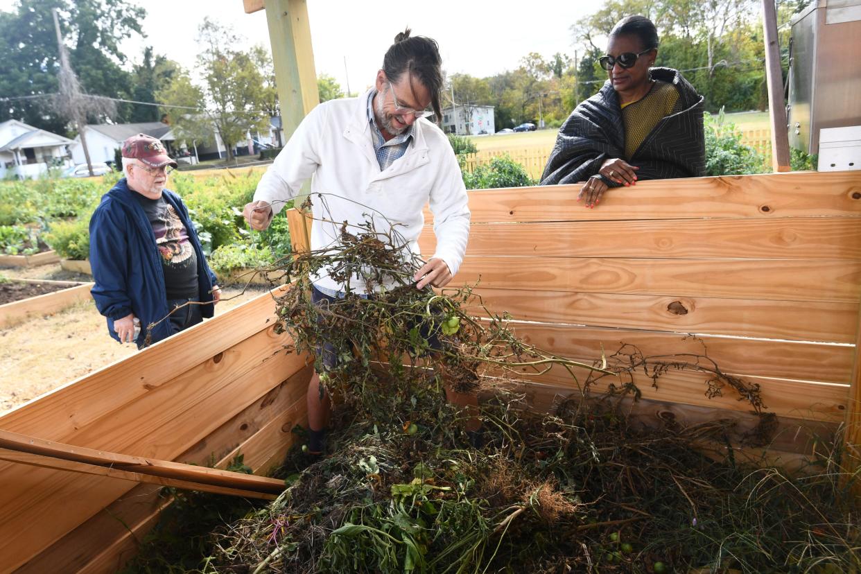 Chad Hellwinckel removes a tomato cage from the compost bin at Payne Avenue Community Garden on Oct. 15.