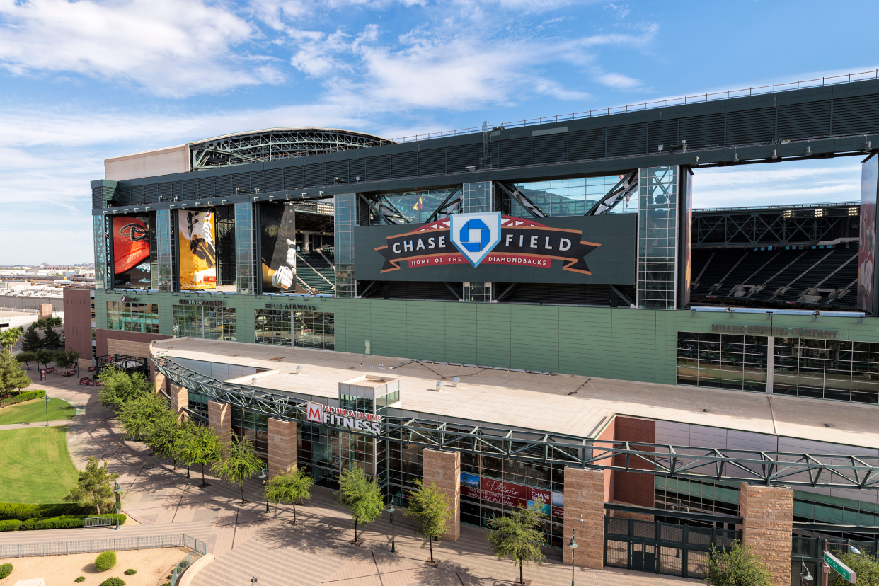 Exterior of Chase Field, Phoenix, home of the Arizona Diamondbacks with front sign with the city and blue sky in the background