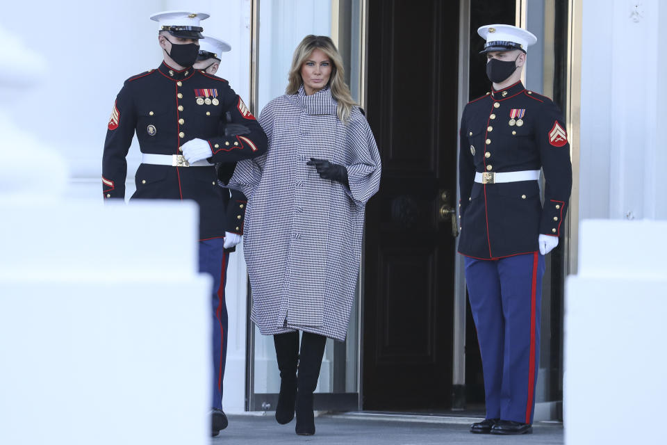 First Lady Melania Trump arrives to receive the White House Christmas tree at the White House on Monday, November 23, 2020 linking arms with a soldier