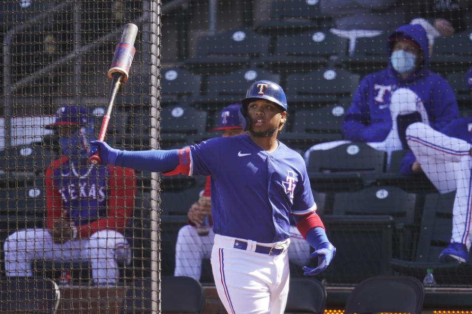 Texas Rangers' Willie Calhoun warms up before batting in the fourth inning of a spring training baseball game against the San Diego Padres, Thursday, March 4, 2021, in Surprise, Ariz. Calhoun, who got hit in the face by a fastball in a 2020 spring training game says he no longer feels like flinching or bailing out on breaking pitches. (AP Photo/Sue Ogrocki)