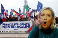 <p>A person holds a mask of France’s National Front (FN) defeated presidential candidate, Marine Le Pen, as people gather with French and European flags near the Eiffel Tower and a banner with the message, “France tells Hate: Never Again” the day after presidential elections in the country, in Paris, France, May 8, 2017. (Pascal Rossignol/Reuters) </p>