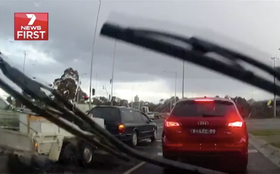 A driver towing a trailer moves halfway across an intersection at a red light. Source: 7 News