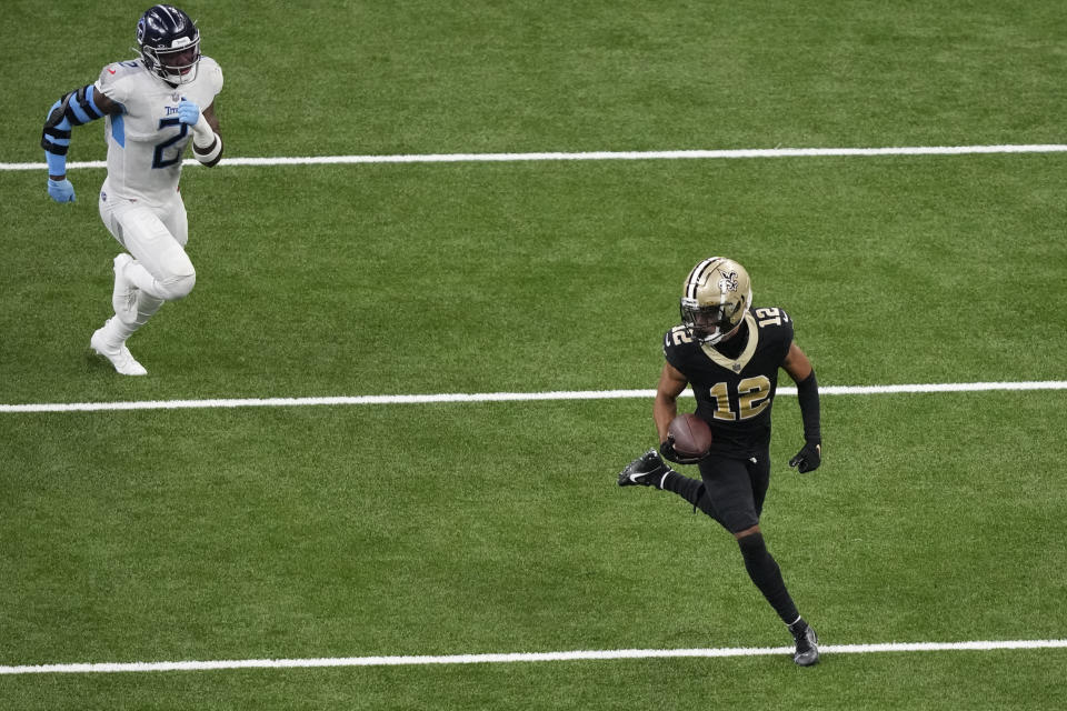 New Orleans Saints wide receiver Chris Olave (12) runs up the field past Tennessee Titans linebacker Azeez Al-Shaair (2) with a 45-yard reception in the second half of an NFL football game in New Orleans, Sunday, Sept. 10, 2023. (AP Photo/Gerald Herbert)