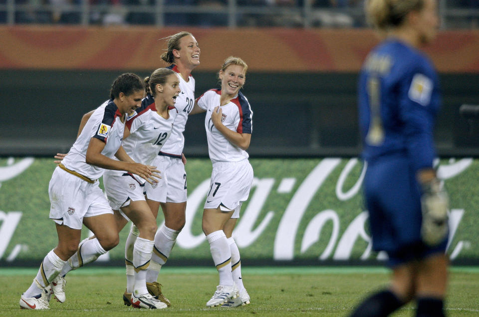 Abby Wambach celebrates with teammates after scoring against England. (Photo credit should read PETER PARKS/AFP/Getty Images)